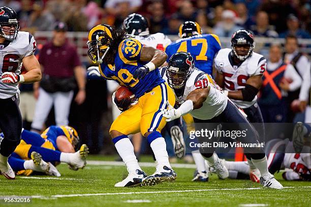 Mario Williams of the Houston Texans tackles Steven Jackson of the St. Louis Rams at Edward Jones Dome on December 20, 2009 in St. Louis, Missouri.