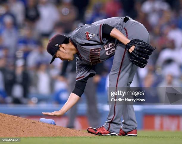 Yoshihisa Hirano of the Arizona Diamondbacks reaches for the rosin bag during the tenth inning against the Los Angeles Dodgers at Dodger Stadium on...