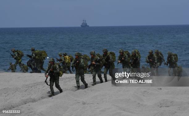 Philippine marines take position as they simulate with their US counterpart an amphibious landing as part of the annual joint military exercise at...
