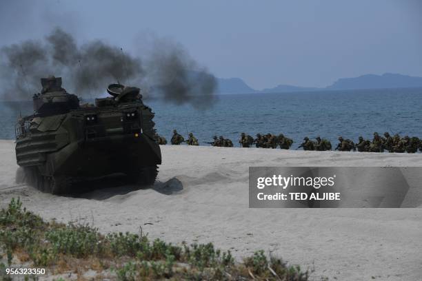 Marines assault amphibious vehicles drives past Philippine marines take position as they simulate an amphibious landing as part of the annual joint...