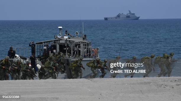 Philippine marines get off from a landing craft as they take position to simulate with their US counterpart an amphibious landing as part of the...