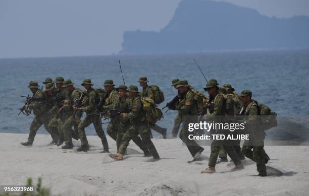 Philippine marines take position as they simulate an amphibious landing with their US counterpart as part of the annual joint military exercise at...