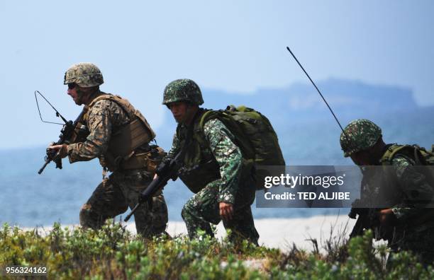 Philippine and US marines take position as they simulate an amphibious landing as part of the annual joint military exercise at the beach of...