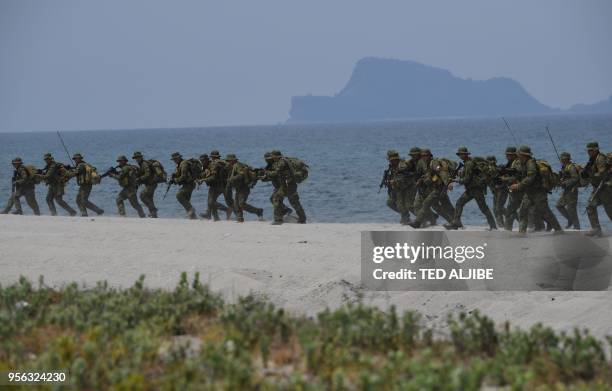 Philippine marines take position as they simulate an amphibious landing with their US counterpart as part of the annual joint military exercise at...
