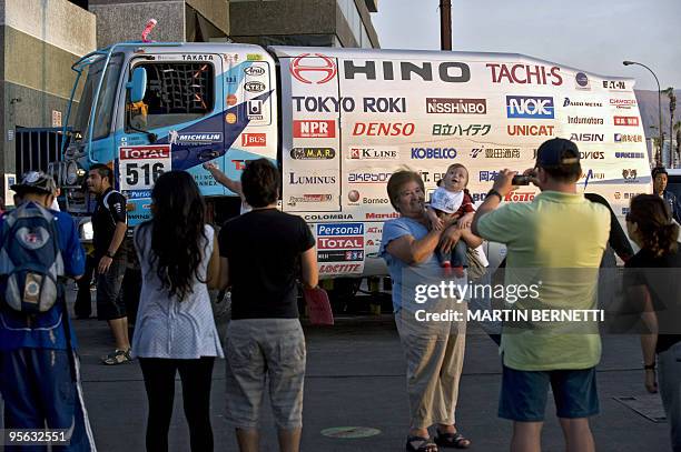 Tourist takes a picture with a Japanese Hino truck Yoshimasa Sugawara in Iquique, 1853 km north of Santiago, Chile, on January 7, 2010. Thousands of...