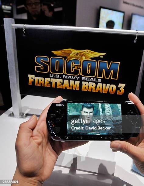 Sony representative displays a PSP 3000 console with SOCOM video game at the 2010 International Consumer Electronics Show at the Las Vegas Convention...