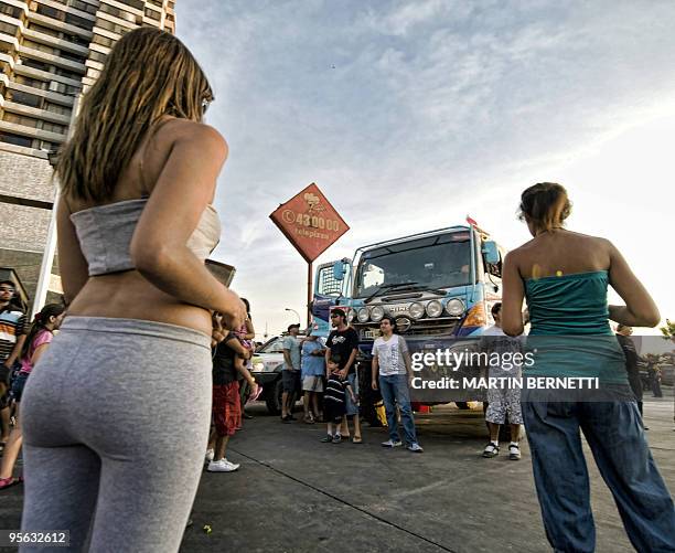 Tourists look at a Japanese Hino truck Yoshimasa Sugawara in Iquique, 1853 km north of Santiago, Chile, on January 7, 2010. Thousands of tourists...