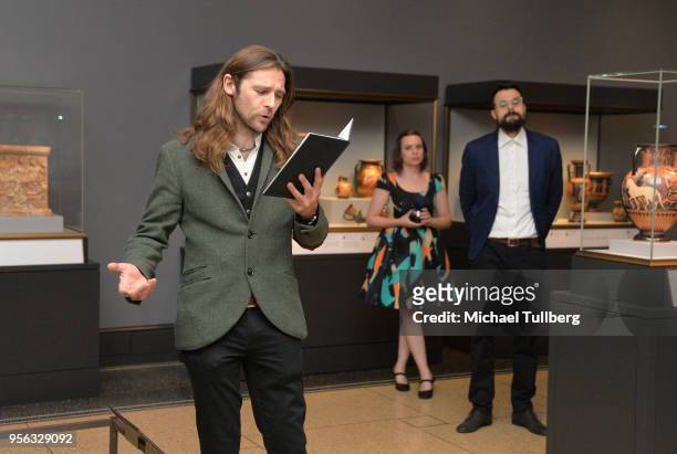 Poet Gabriele Tinti watches as filmmaker Oscar Sharp recites Tinti's poetry at BritWeek at The Getty Villa on May 8, 2018 in Pacific Palisades,...