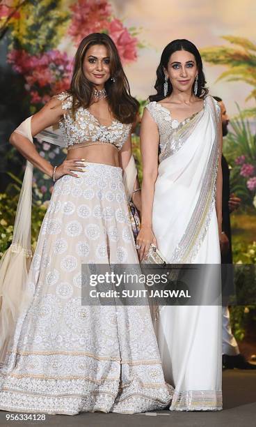 Indian Bollywood actresses Amrita Arora and Karishma Kapoor pose for a picture during the wedding reception of actress Sonam Kapoor and businessman...