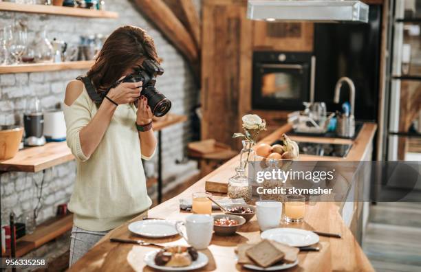 female photographer taking photos of food at dining table. - freelance work photos stock pictures, royalty-free photos & images