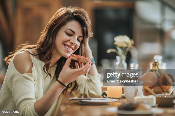 young smiling woman having breakfast in the kitchen. - marmalade sandwich stock pictures, royalty-free photos & images