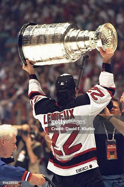 Rear view of New Jersey Devils Claude Lemieux victorious with Stanley Cup trophy after winning Game 4 and series vs Detroit Red Wings. East...