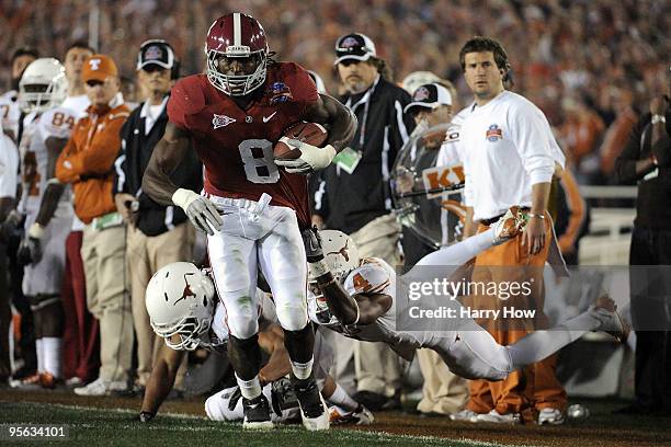 Wide receiver Julio Jones of the Alabama Crimson Tide runs with the ball as he is grabbed by cornerback Aaron Williams of the Texas Longhorns during...