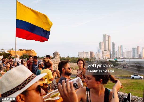 people watching sunset at cafe del mar, located at the historic bastion city walls, baluarte de santo domingo, cartagena de indias, colombia. - mar caribe foto e immagini stock