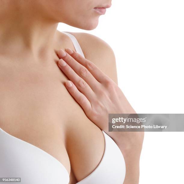 woman touching her chest - weibliche brust fotos stock-fotos und bilder