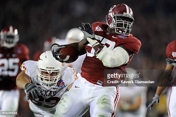 Lineman Marcell Dareus of the Alabama Crimson Tide runs with the ball after an interception as guard Michael Huey of the Texas Longhorns attempts to...