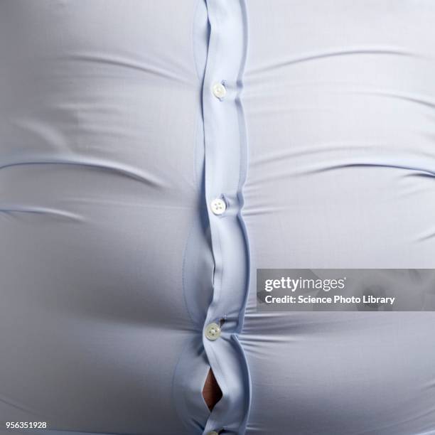 overweight man with bulging shirt buttons - demasiado pequeño fotografías e imágenes de stock