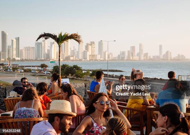 people watching sunset at cafe del mar, located at the historic bastion city walls, baluarte de santo domingo, cartagena de indias, colombia. - mar caribe foto e immagini stock