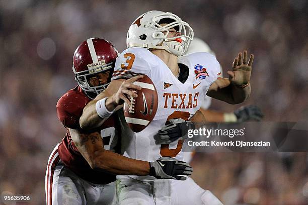 Quarterback Garrett Gilbert of the Texas Longhorns fumbles the ball as he is hit by linebacker Eryk Anders of the Alabama Crimson Tide during the...