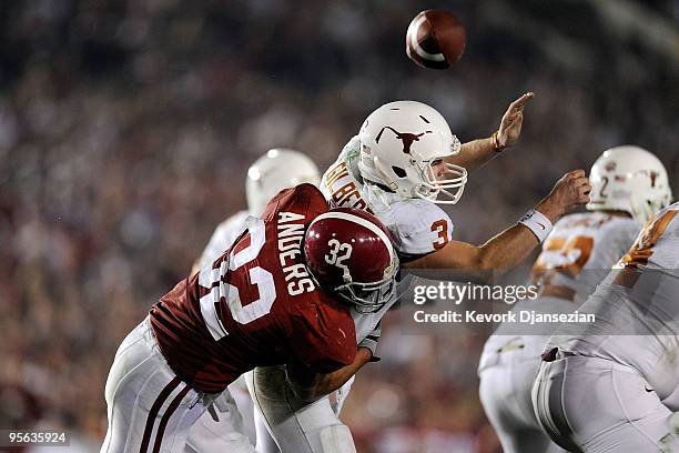 Quarterback Garrett Gilbert of the Texas Longhorns fumbles the ball as he is hit by linebacker Eryk Anders of the Alabama Crimson Tide during the...