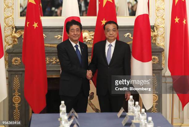 Shinzo Abe, Japan's prime minister, left, and Li Keqiang, China's premier, shake hands prior to a bilateral summit in Tokyo, Japan, on Wednesday, May...