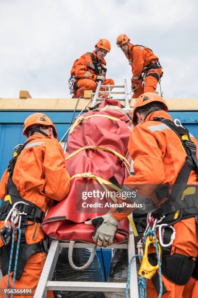 firefighters in a rescue operation - accident on the roof - rope high rescue imagens e fotografias de stock