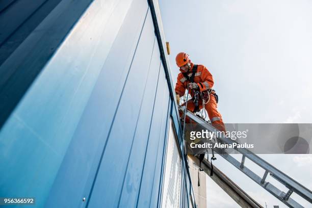 firefighters in a rescue operation - accident on the roof - rope high rescue imagens e fotografias de stock
