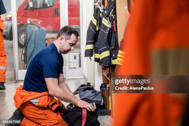 firefighter in a locker room - firefighter getting dressed stock pictures, royalty-free photos & images