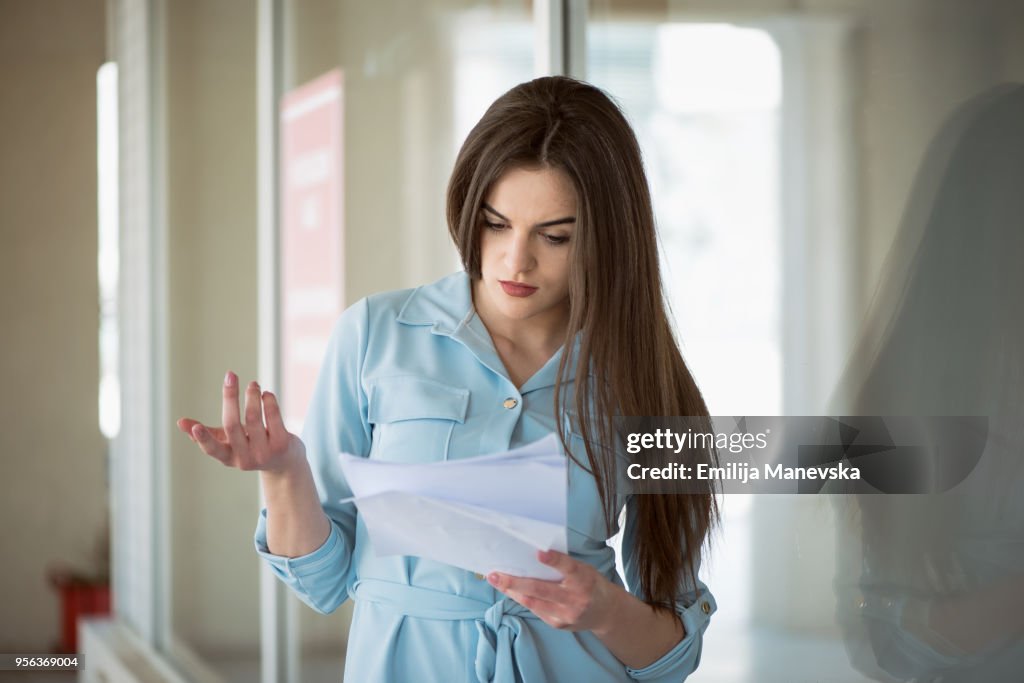Portrait of a young woman reading bad letter