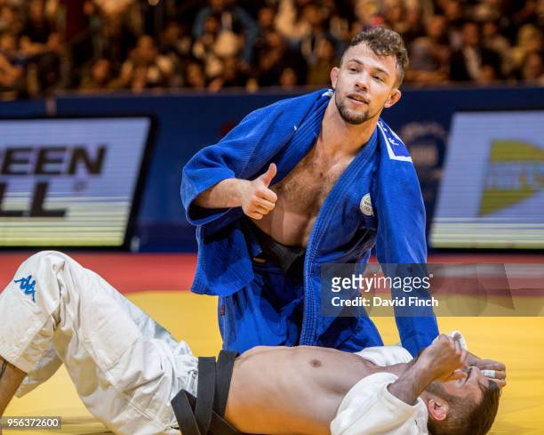 Adrian Gomboc of Slovenia signals his victory after holding Matteo Medves of Italy for an ippon to win the u66kg gold medal during day one of the...