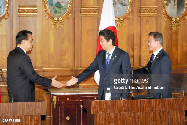 Chinese Premier Li Keqiang, Japanese Prime Minister Shinzo Abe and South Korean President Moon Jae-in shake hands during a joint press conference...