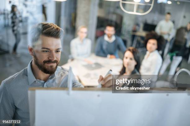 junge unternehmer schriftlich vorschläge auf tafel bei einem treffen mit seinen kollegen. - präsentieren whiteboard stock-fotos und bilder