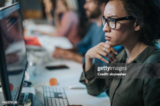 geconcentreerd african american vrouw brainstormen tijdens het coderen van gegevens op desktop pc. - woman coding stockfoto's en -beelden
