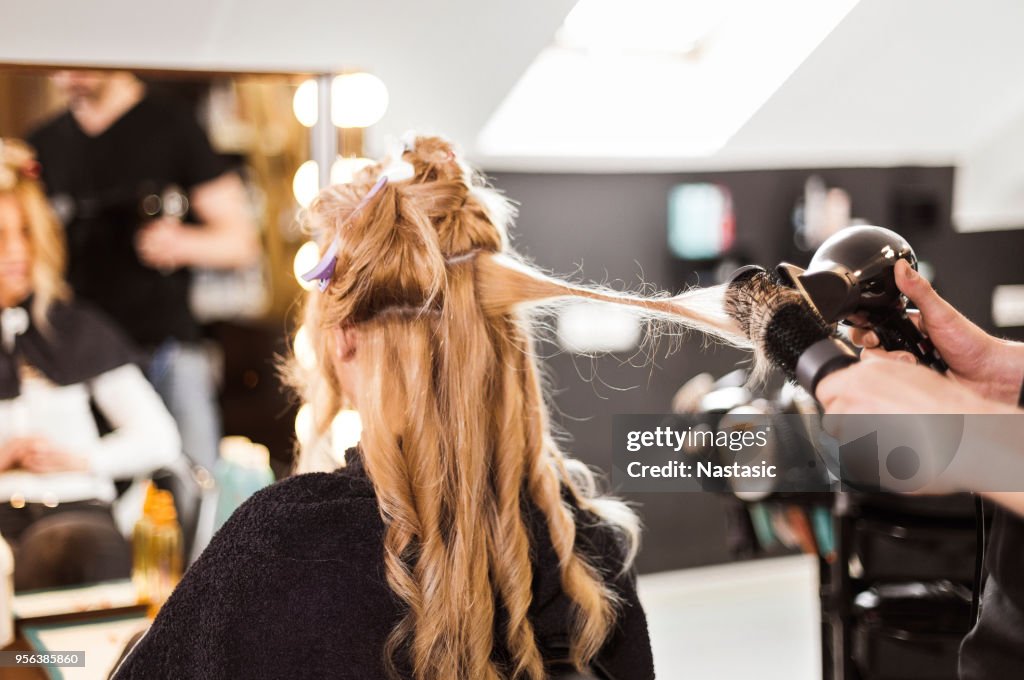 Hairdresser using hairdryer