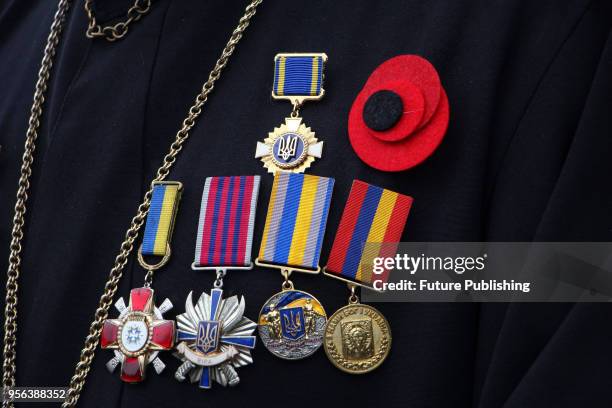 Medals and a poppy lapel pin decorate a black cassock of a priest during a tribute-paying ceremony at the Tomb of the Unknown Sailor on the Day of...