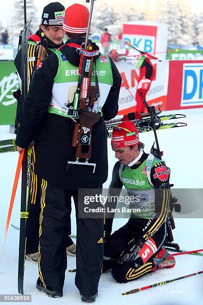 Simon Schempp of Germany knees in the snow next to team mates Christoph Stephan and Arnd Peiffer during the Men's 4 x 7,5km Relay in the e.on Ruhrgas...