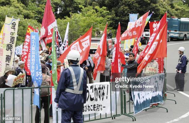 People protest against the restart of the No. 4 reactor at the Oi nuclear plant near a gate of the complex in the central Japan prefecture of Fukui...