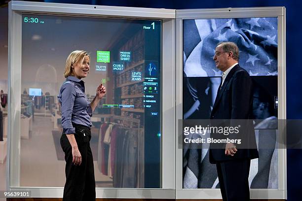 Paul Otellini, chief executive officer of Intel Corp., right, looks on as a touch-sensitive panel for retail use is demonstrated during the 2010...