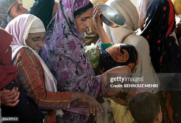 Pakistani women queue to receive donated food at the courtyard of the shrine of Sufi Saint Beri Imam in Islamabad on January 8, 2010. Bari Imam who...