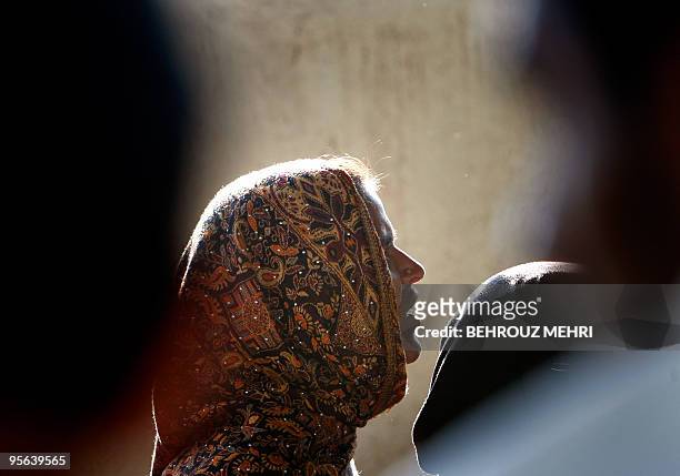 Pakistani woman queues to receive donated food at the courtyard of the shrine of Sufi Saint Beri Imam in Islamabad on January 8, 2010. Bari Imam who...
