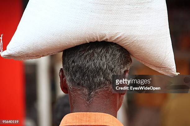 Local vendor with rice on his head at the food market of Kottayam on December 28, 2009 in Kottayam near Trivandrum, Kerala, India.