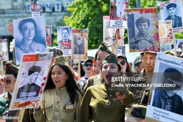 People carry portraits of World War Two soldiers during the Immortal Regiment march in Bishkek on May 9, 2018. - Kyrgyzstan and other ex-Soviet...