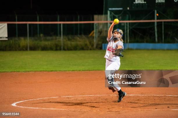 woman softball pitcher throwing the ball - softball pitcher stock pictures, royalty-free photos & images