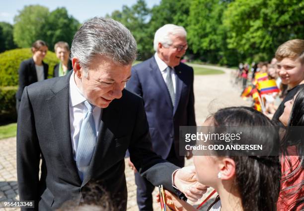 Colombian President Juan Manuel Santos and his German counterpart Frank-Walter Steinmeier talk with young wellwishers during a welciming ceremony at...