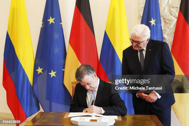 German President Frank-Walter Steinmeier stands as Columbian President Jose Manuel Santos signs the Guestbook upon Santos's arrival at Schloss...