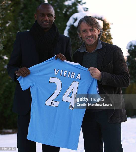 Patrick Vieira poses with his new manager Roberto Mancini as he signs for Manchester City during a photocall at their Carrington Training Ground on...