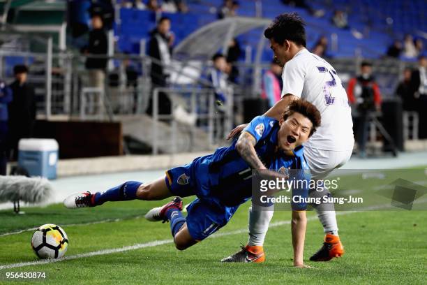 Hwang Il-Su of Ulsan Hyundai is tackled by Lee Ki-je of Suwon Samsung Bluewings during the AFC Champions League Round of 16 first leg match between...