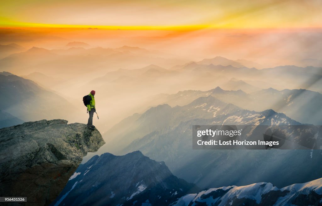 Mountain climber standing on edge of mountain, looking at view, Courmayeur, Aosta Valley, Italy, Europe