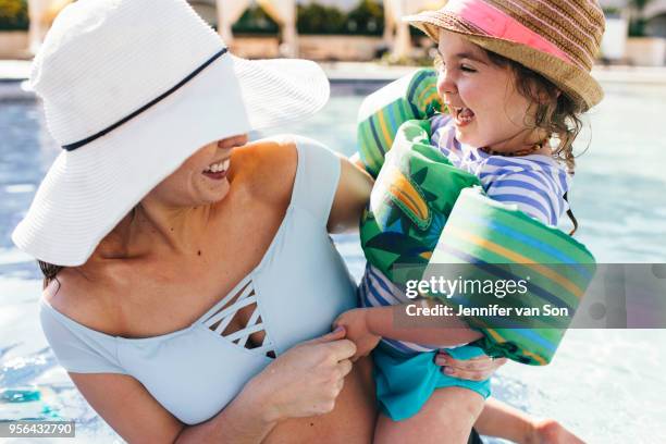 mother and holding young daughter in outdoor swimming pool - punta cana stock pictures, royalty-free photos & images