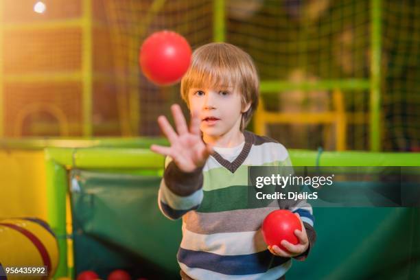 happy young boy playing in children games room. - kid throwing stock pictures, royalty-free photos & images